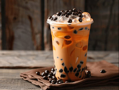 Glass of bubble tea with black tapioca pearls on a wooden surface